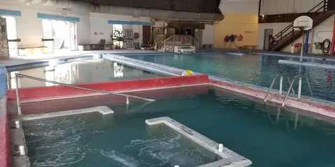 An indoor swimming pool facility with multiple pools and hot tubs.