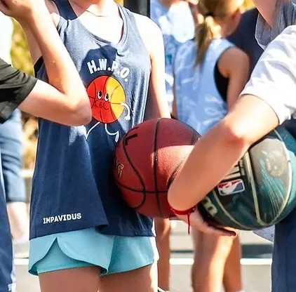 People holding basketballs outdoors.