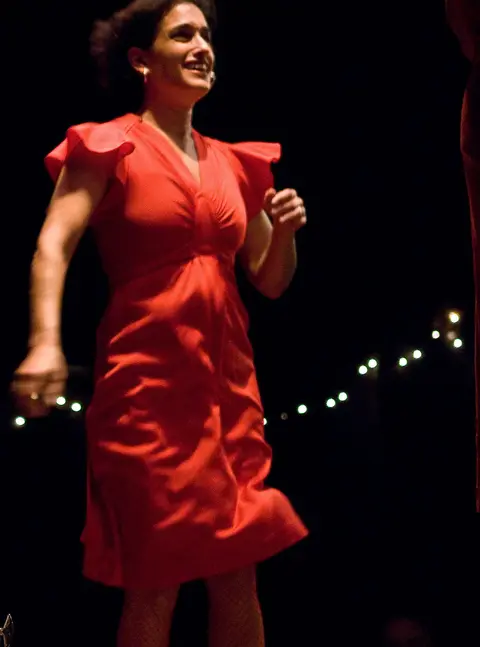 A woman in a red dress dancing.