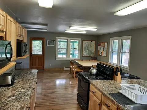 An interior view of a kitchen and dining area in a cabin.