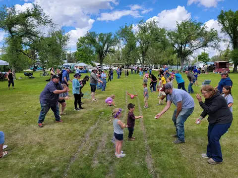 People participate in an outdoor lawn game on a grassy field.