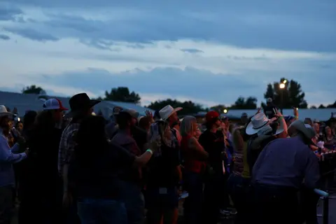A crowd of people enjoying an outdoor event at dusk.