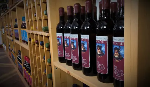 Bottles of wine arranged on wooden shelves inside a store.