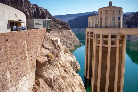 A view of the intake towers and structures at a large dam next to a reservoir.