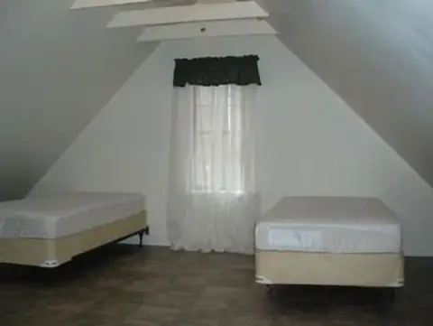 An attic bedroom with sloped ceilings and two beds.