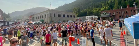 A large crowd of people gathered in a street during an outdoor event.