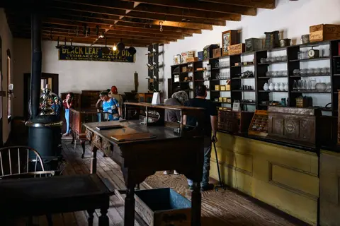 Interior view of a historic general store with shelves of merchandise and visitors.
