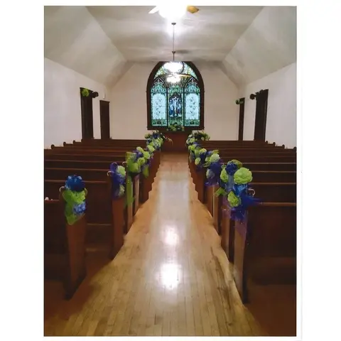 Interior view of a church with wooden pews decorated for an event.