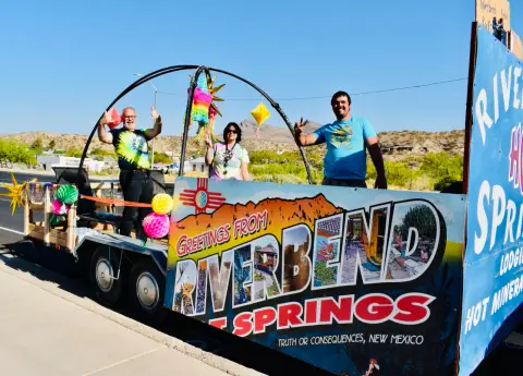 Three people posing on a decorated parade float.
