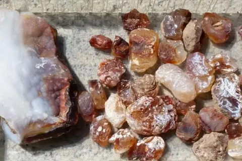 A collection of colorful stones displayed in a container.