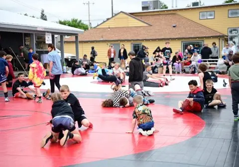 A group of people participating in an outdoor wrestling event.