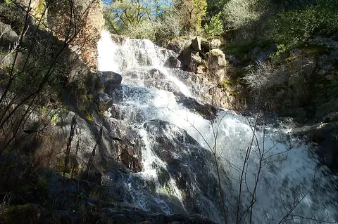 A view of water flowing over rocks in a natural waterfall.