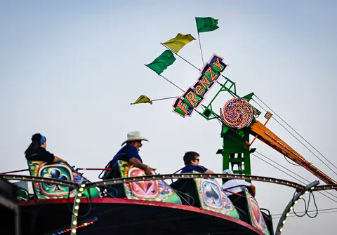 People enjoy riding an amusement park ride at a fair.