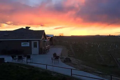 A sunset over a building and fields.