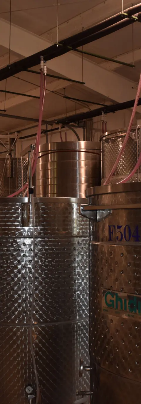 Large stainless steel tanks inside a production facility.