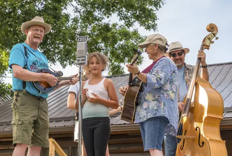 A band of musicians plays music outdoors.