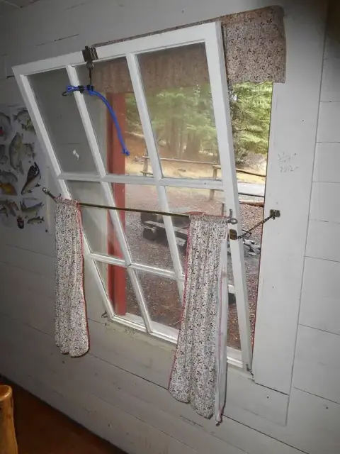 An interior view looking out through an open multi-pane window.