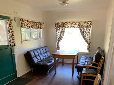 An interior view of a room with two futons, a table, and chairs.