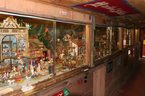 An indoor display features a large miniature village diorama behind glass cabinets.