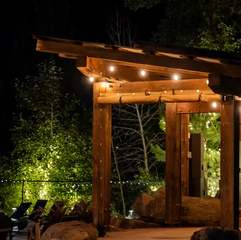 A wooden structure illuminated by string lights at night.