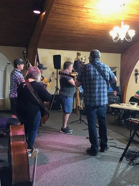A band playing acoustic music inside a building.