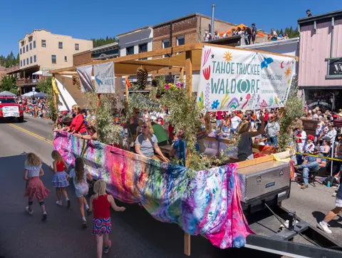 A parade float driving down a street lined with crowds.