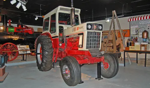 A vintage tractor on display inside a museum.
