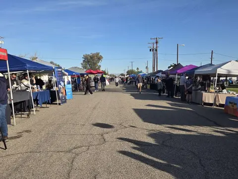 A street market with many tents lining both sides of the road.