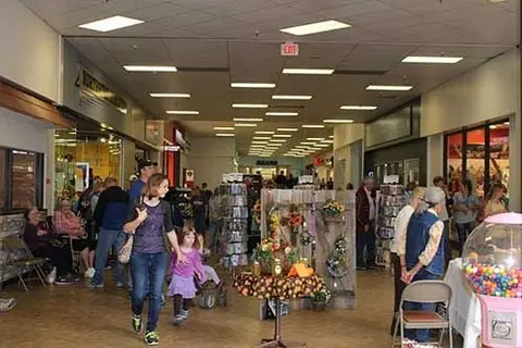 People walking through an indoor shopping mall hallway.