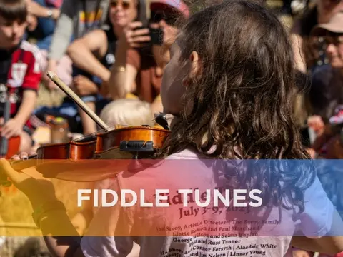 A young person playing the violin in front of a crowd.