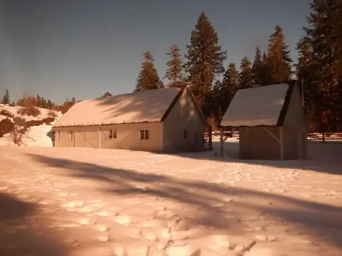A snowy landscape with buildings and trees.