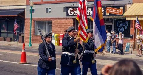 A color guard marching down a street during a parade.