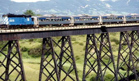A train crosses a high trestle bridge.