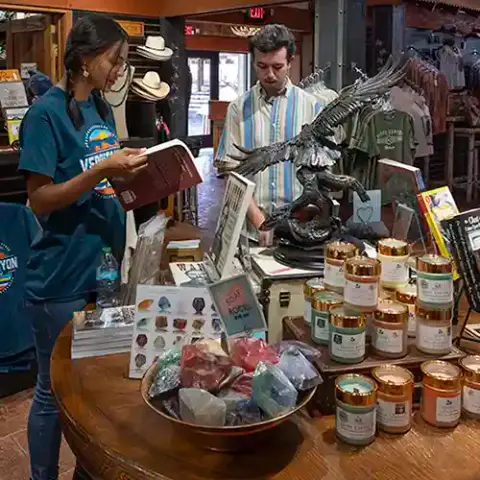 Two people browse inside a gift shop filled with merchandise.