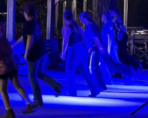 A group of people dancing in blue light.