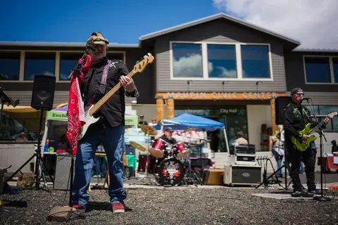 A band performs outdoors in front of a building.
