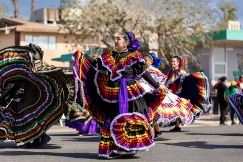 Dancers in colorful traditional dresses perform outdoors.