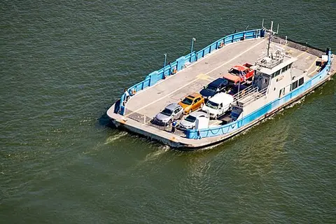An aerial view of a ferry transporting cars across the water.