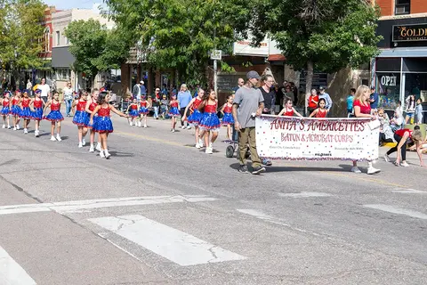 A baton and acrobat corps marches in a street parade.
