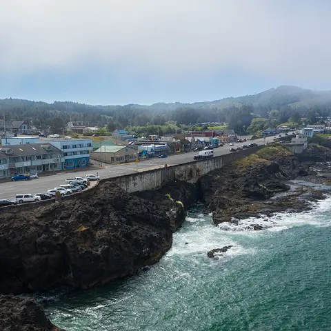 An elevated view of a coastal town next to rocky cliffs and ocean water.