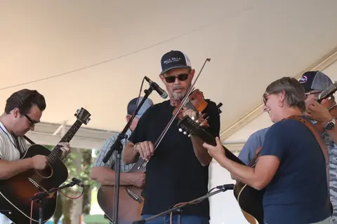 A band playing acoustic music on a stage.
