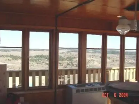 Interior view looking out a row of windows at a landscape.