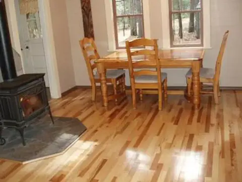 An interior view of a dining room with a wooden table, chairs, and a stove.