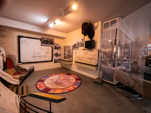 A museum interior featuring historical exhibits, displays, and a map on the floor.