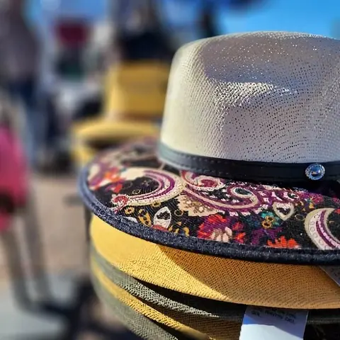 A close-up shot of a stack of hats, with a patterned brim on top.