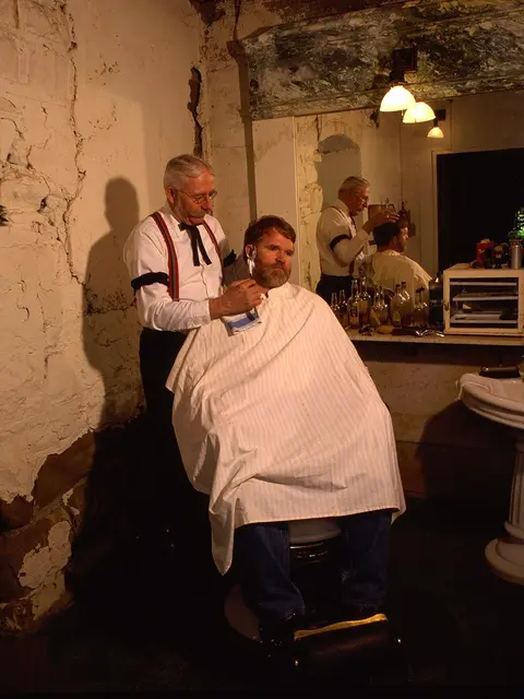 A barber shaves a customer in an old-fashioned barbershop.