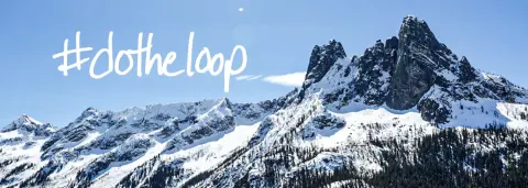 Snow-covered mountains under a clear blue sky with handwritten text overlaid.
