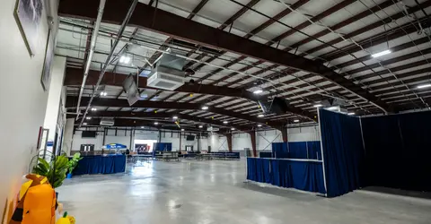 A wide interior shot of a large industrial warehouse or event space.