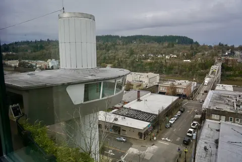 A high-angle view of a white observation tower overlooking a town.
