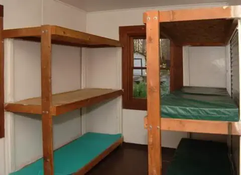 An interior view showing wooden bunk beds with mattresses.
